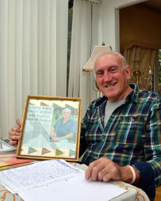 Picture of man holding a framed newspaper clipping