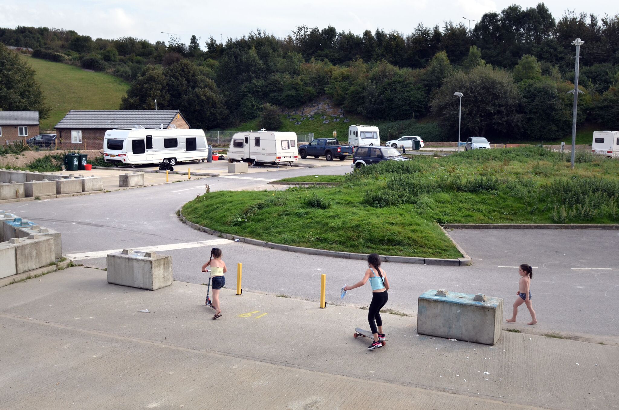 Picture of girls on skateboard and scooters on a caravan park`