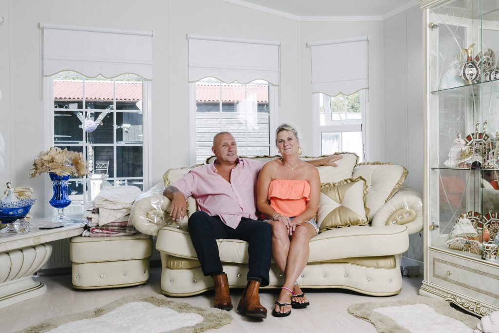 Picture of man and woman smiling together sat on a sofa