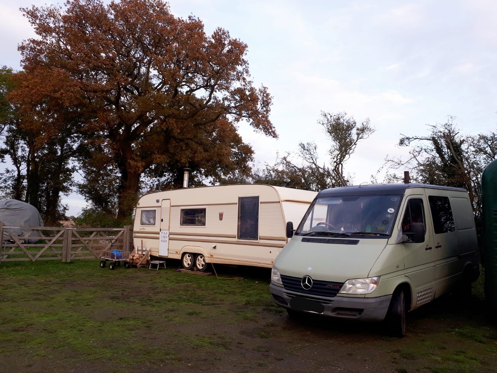 A mobile home with a transit van on a green field