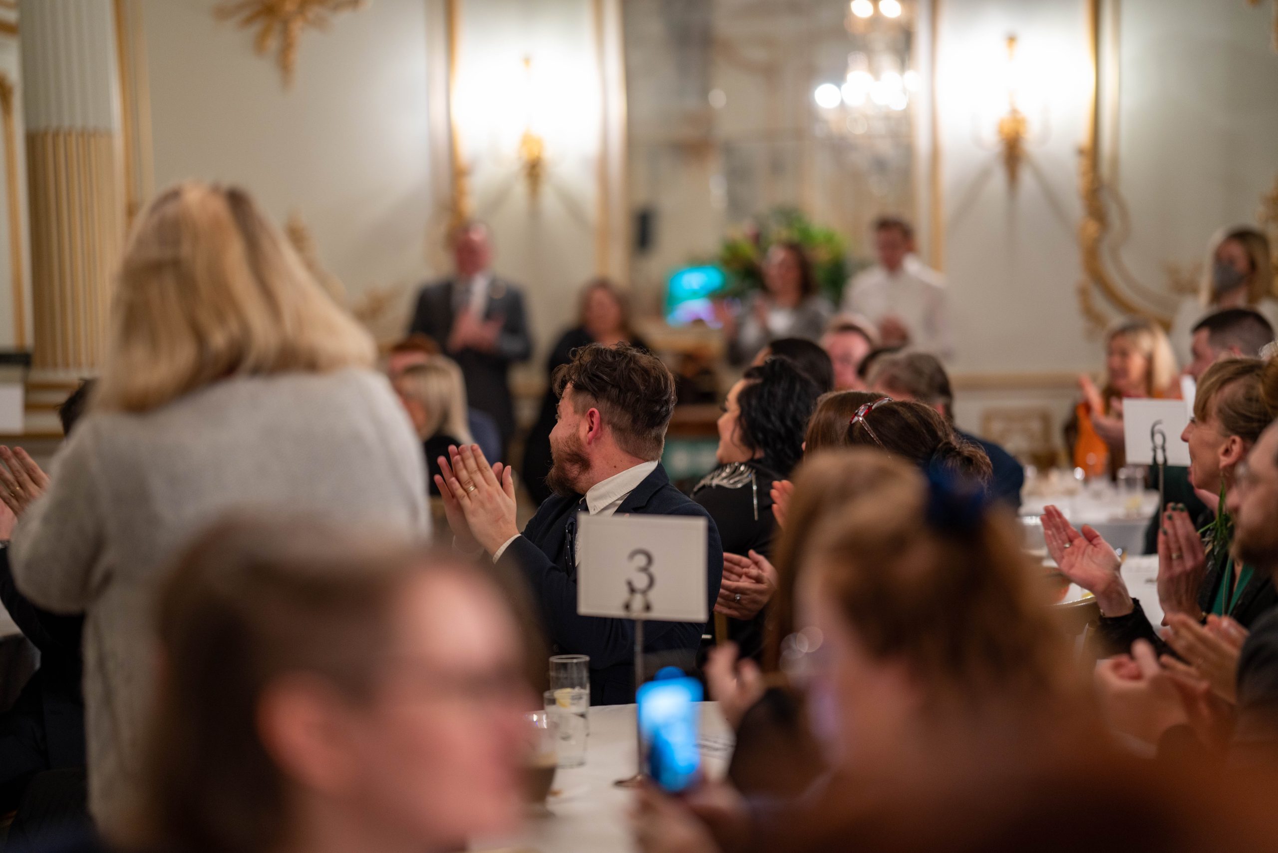 People at an awards ceremony clapping.