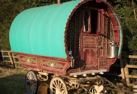 Picture of traditional Gypsy wagon next to a fence