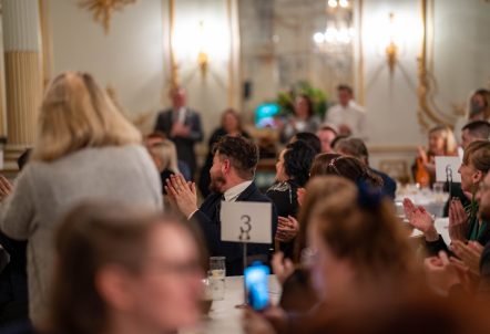 People at an awards ceremony clapping.