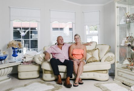 Picture of man and woman smiling together sat on a sofa
